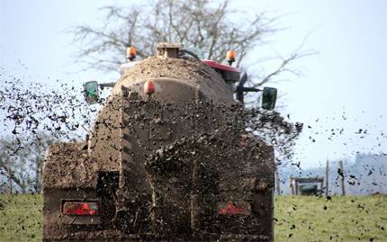 Traktor som sprider gödsel