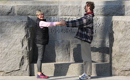 Birgitta Lind och Felix Tärnbrant håller varandras händer framför Fredsmonumentet