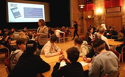 Elever i årskurs 8 sitter i diskussionsgrupper runt bord i Folkets Hus