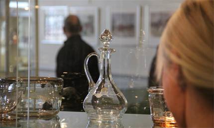 Kvinna som tittar på utställning på Eda glasbruks museum